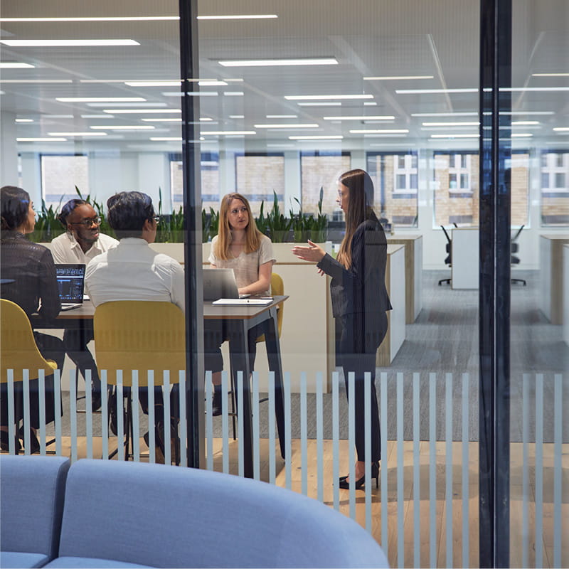 Meeting in an open plan office to illustrate Private Equity