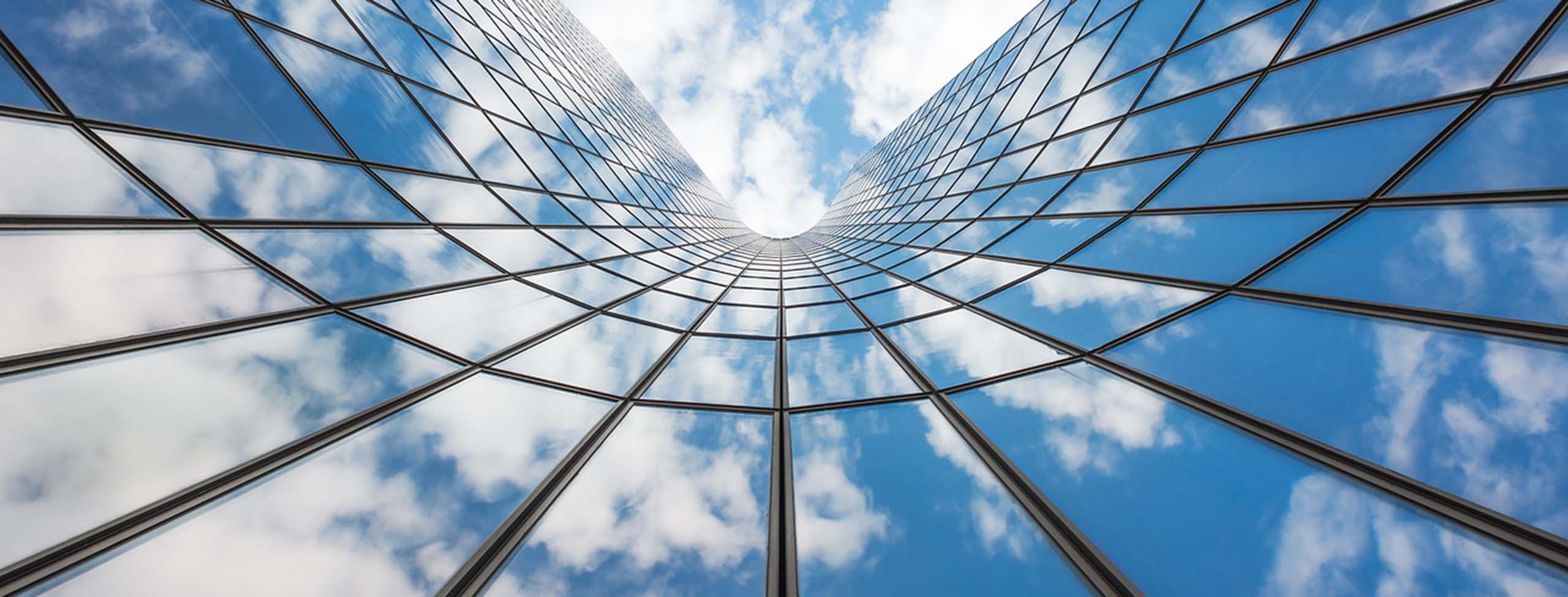 blue sky and white clouds reflected in glass building