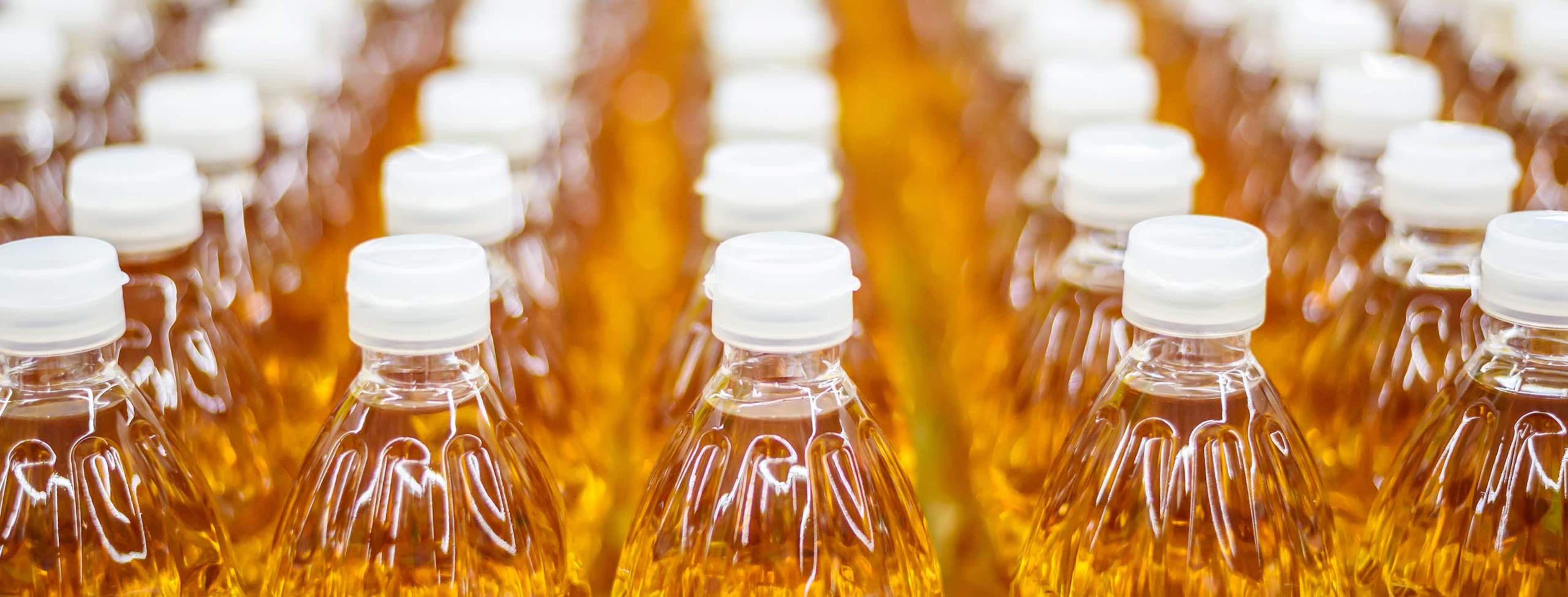 close-up image of clear soda bottles in a factory line
