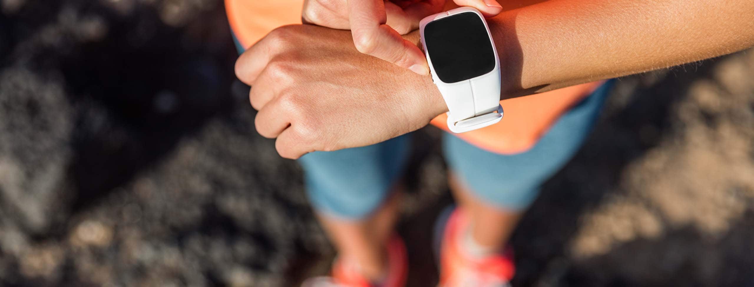 trail runner using her smart watch to monitor fitness